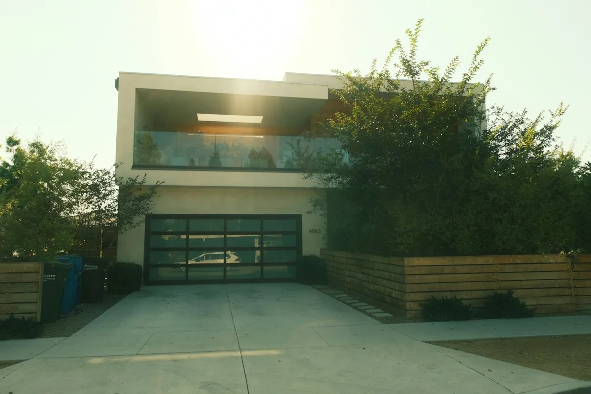 Modern house with a glass-panel garage door at sunset